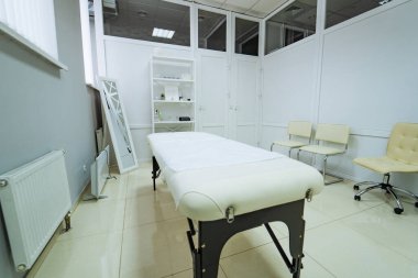 İçi boş masaj terapi odası. Tedavi yatağı ve minimalist tasarımı olan temiz masaj terapi odasının içi.