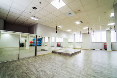 Aynalı modern fitness stüdyosu. Büyük aynaları, sahne platformu ve eğitim ekipmanlarıyla parlak modern fitness stüdyosu.