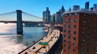 Manhattan 'a giden ve oradan da East River rıhtımına giden yollarda hareketli bir trafik var. Çok katlı tuğla binadaki İHA görüntüleri. Arkaplanda Brooklyn Köprüsü.