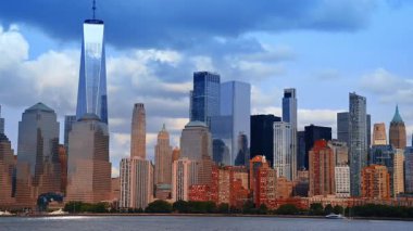 New York 'un çarpıcı manzarasında dramatik bulutlar gökyüzünü kaplıyor. Nehir manzarasından şehre alçak açılı görüş.