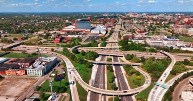 Büyük şehirdeki karmaşık yol sisteminde araba akışı. İHA 'dan güneşli bir günde Detroit, Michigan' ın yeşil panoraması. Detroit, ABD, 28 Temmuz 2025: