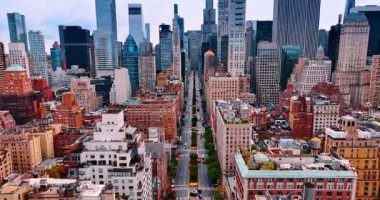 New York 'un geniş şeritli sokağında çoklu sarı taksiyle uçuyor. New York şehir merkezindeki yüksek binalara yaklaşıyoruz..