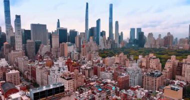 Çarpıcı Central Park boyunca yerleşim alanındaki çeşitli binalara yaklaşıyoruz. Arka planda muhteşem gökdelenler var. New York, ABD 'de sonbahar.