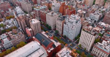 New York civarındaki çeşitli binaların çatılarına bakın, cadde boyunca çok sayıda sarı taksi hareket ediyor. Hava perspektifi.