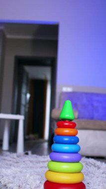 Şirin çocuk piramidi aldı ve etrafında yürümeye başladı. Bebek oyuncağa yaklaşır ve onu ters çevirir. Dikey video