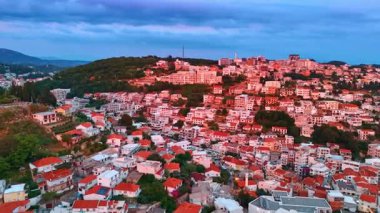 Turuncu güneş ışığı yeşil dağlarda kırmızı çatıları olan birçok villayı renklendiriyor. Karadağ 'daki tatil beldesinin geniş şehir manzarası İHA' dan.