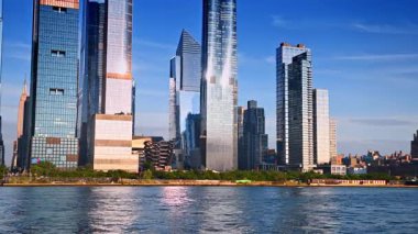 Parlak güneş, ABD 'nin New York kentindeki Vessel Structure etrafındaki yüksek binaların cam cephelerine yansıyor. Bottan Metropolis 'in yeşil rıhtımına bak..