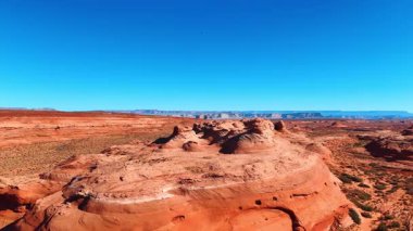Flying away form the beautiful sandstone rocks located in the vast desert. Beautiful clear blue sky at backdrop. Utah, USA.