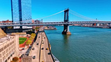 Moving over the multi-lane highway on the waterfront of the East River. Approaching the beautiful Manhattan Bridge in New York, USA on sunny day.