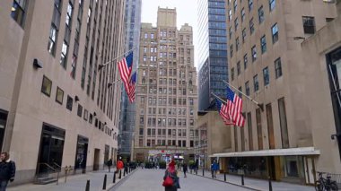 New York, USA, 6 November 2025: Grey high-rises with American flags on the facades. View on the street of New York, USA at daytime.