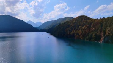 Mountain lake under soft light. A serene alpine lake surrounded by wooded mountain slopes.