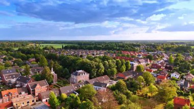 Settlement near wide green fields. Aerial view of a Dutch settlement located beside broad green farmlands.