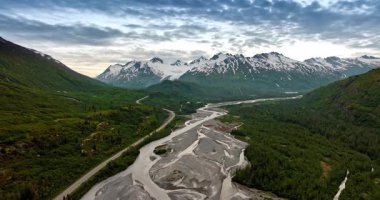 River and glacier valley Alaska. Aerial river and glacier valley framed by steep snow-topped mountains