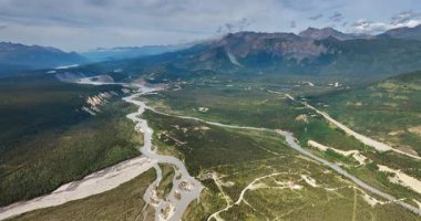 Alaska river winding through forest. Aerial river winding through dense Alaskan forest and mountain terrain