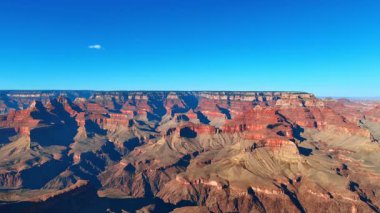Vast canyon horizon in daylight. A vast open canyon expands into the distance under daylight.