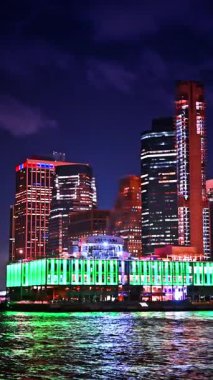 New York, USA, 8 August 2025: Moving by the river along the luminous Pier 17 bar in the evening. NYC's most scenic concert venue from the East River. Vertical video.