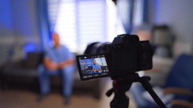 Working modern camera with a display showing a man in blue uniform. Close up. Medical blog creation. Selective focus.