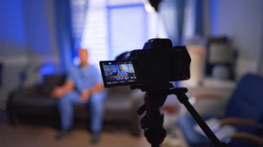 Mavi üniformalı doktoru gösteren bir kamera. Ofiste tıbbi içerikli video oluşturma. Seçici odak.
