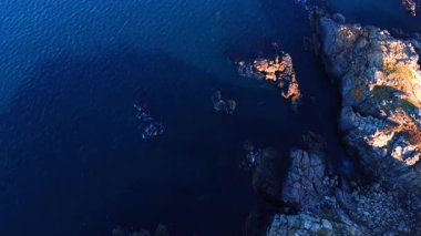 Mavi su manzarası kayalık kıyılarla buluşuyor. Deniz kıyısındaki ya da okyanustaki ulaşılamaz uçurumlar. Üst görünüm.