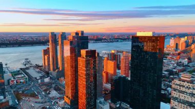 New York, ABD, 8 Ağustos 2025: Günbatımının altın ışığı New York, ABD 'deki gökdelenlerin cephelerini aydınlatıyor. Arkaplanda Doğu Nehri kıyısı.