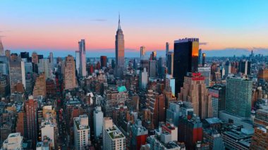 New York, ABD, 8 Ağustos 2025: New York, ABD 'nin muhteşem şehir manzarası üzerinde gidiyoruz. Pembe gökyüzü gün batımında arkaplanda.