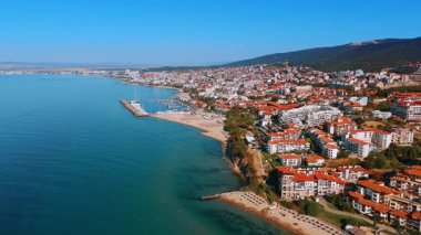 Densely built slopes of the mountains descending into the Black Sea. Hotels of sunny Bulgaria resort in Sveti Vlas. Aerial view.