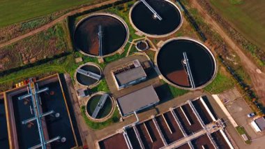 Diverse shapes of the reservoirs for water in the sewage treatment plant. Water tanks for sewage recycling from drone view.