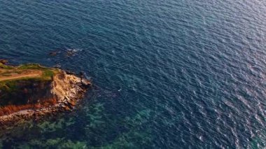 Ridged blue waterscape of the sea or ocean from drone footage. View on the rocky shore.