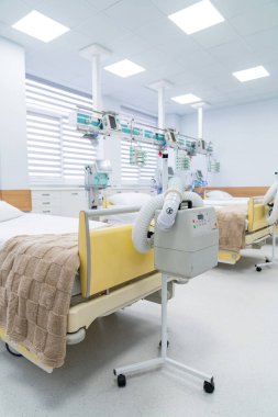 Clean intensive care ward interior. Empty intensive care unit with beds, monitors and life support machines in bright sterile hospital space.