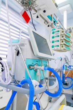 Side angle of intensive care ventilator. Medical breathing device on stand near hospital bed in ICU