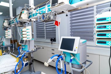 Row of ventilators in hospital ICU. Several life support machines aligned beside beds in critical ward