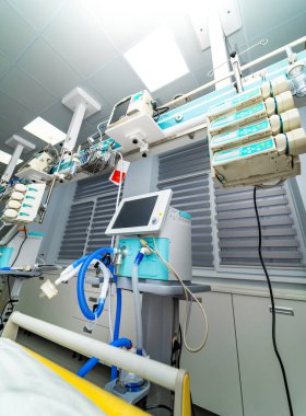 ICU ventilator setup beside patient bed. Close view of hospital ventilator connected to intensive care equipment.