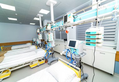 Modern ICU beds in bright medical ward. Clean intensive care room with aligned beds and advanced monitors.