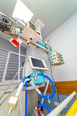 Medical monitors on ICU equipment rails. Suspended medical monitors and pumps arranged along intensive care system rails.