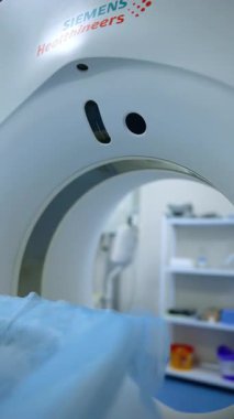 Kyiv, Ukraine, 2 August 2025: Modern CT scanner ready for an examination. The table with a blue cover is positioned in the gantry opening of the white machine.