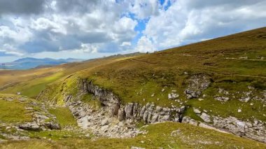 Deep mountain valley viewed from above. Forested slopes descend steeply into the canyon below.