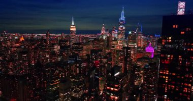 Iconic view of beautiful Manhattan at night. Drone footage over the downtown of New York, USA approaching the tops of the famous skyscrapers.