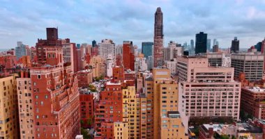 Flight over diverse urban landscape of New York, USA. Cloudy sky at backdrop. Gloomy daytime in metropolis.