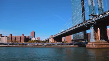 Approaching the Manhattan Bridge by the boat. River tour by the East River in New York on sunny day.