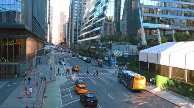 New York, USA, 28 August 2025: Wide street of modern New York, USA. Aerial view. People walk by the sidewalks, cross the road and ride in the transport.