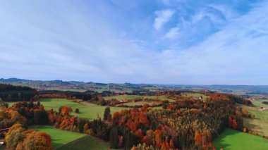 Wide mountain forest landscape in full autumn color. Mist hangs low over the trees covering the slopes.