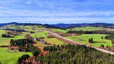 Wide view of autumn fields and hills. Expansive autumn landscape with bright fields, winding roads and forested hills.