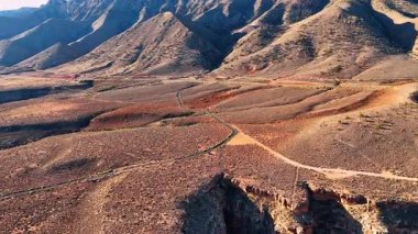 Approaching the roads crossing the dry barren landscape lit by the bright sun. Drone footage in Marble Canyon, Coconino County, Arizona, United States.