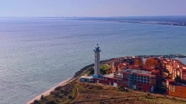 Renkli ev kompleksinin bitişiğindeki kare şeklindeki deniz fenerinden uzakta. Arka planda Karadeniz 'deki su manzarası. Hava görünümü.