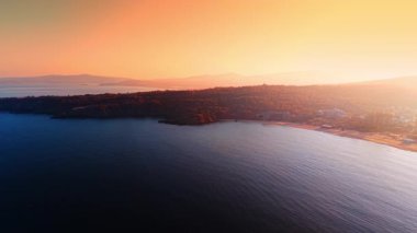 Güz mevsiminde ağaçlarla kaplı güzel su manzarası ve kayalık kıyı şeridi. İnsansız hava aracından inanılmaz gün batımı zamanı.