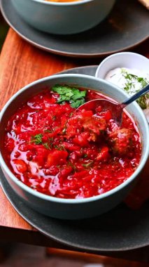 Tostlu pancar çorbası. Ahşap bir masada kızarmış ekmekle servis edilen buğulanmış pancar çorbası..