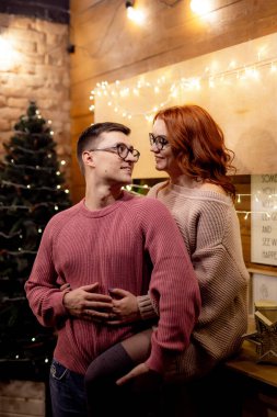 Işıklarda kucaklaşan bir çift. Ilık odada çift kucaklaşması. Parlak iplik ışıkları..