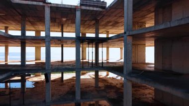 Deniz kıyısında yeni bir gökdelen inşaatı. Güneş, arka plandaki engin deniz manzarasını kamaştırıyor..