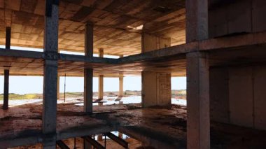 Tamamlanmamış yapının zemininde biraz çöp var. Deniz kıyısında inşaat..