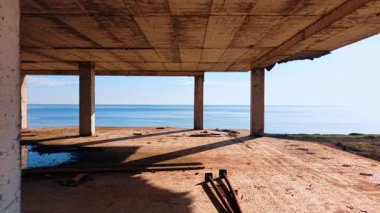 Çok katlı tamamlanmamış binanın içindeki görüntüler. Güzel, engin, huzurlu deniz manzarası.